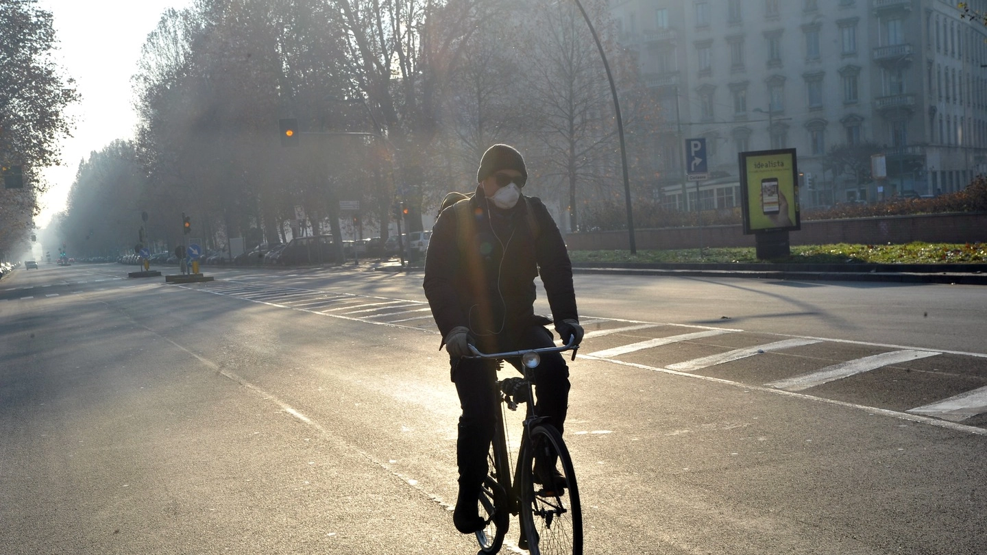 Smog, un ciclista con la mascherina (foto Newpress)