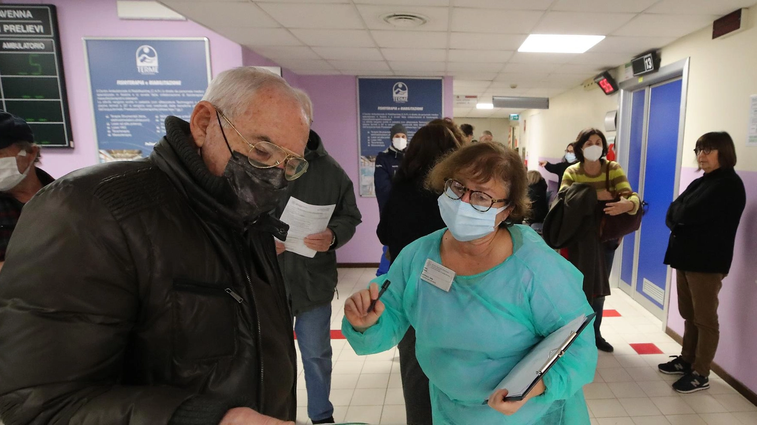 Un paziente chiede informazioni sulla compilazione del modulo prima di vaccinarsi (foto Fabrizio Zani)