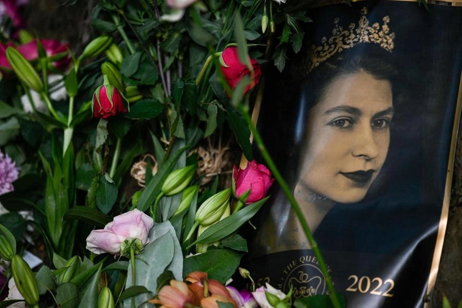 Il ritratto della regina Elisabetta II tra i fiori fuori da Buckingham Palace (Ansa)