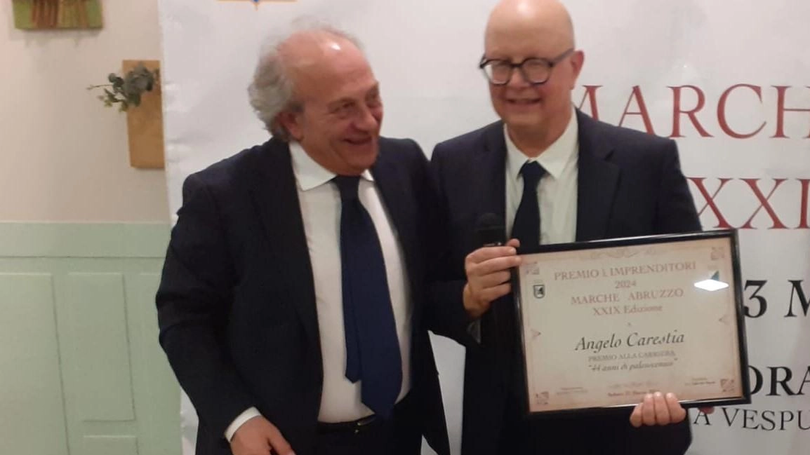 L'attore Angelo Carestia premiato per i suoi 44 anni di carriera durante la manifestazione 'Premio per Imprenditori 2024 Marche e Abruzzo'. Autorità locali presenti alla cerimonia.