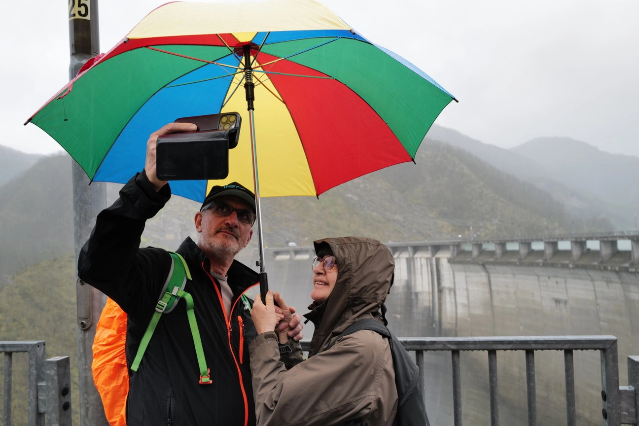 Alcuni visitatori sul coronamento della diga nonostante la pioggia di ieri: il panorama merita comunque un selfie (foto Cristiano Frasca)