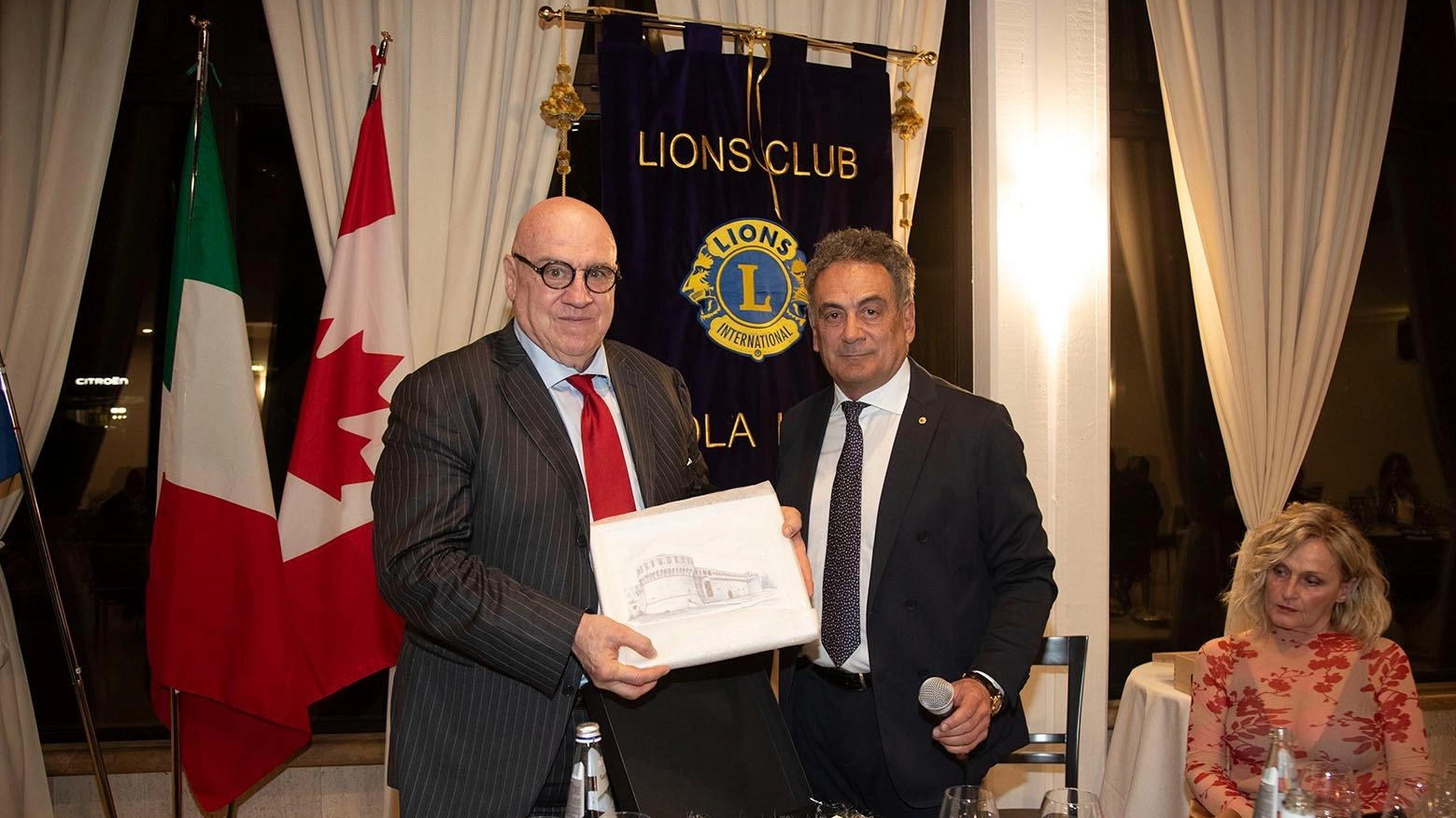 L'imprenditore Alberto Forchielli tiene una conferenza sullo stato dell'economia mondiale al Lions Club Imola Host, ricevendo omaggio per il suo contributo nel settore.