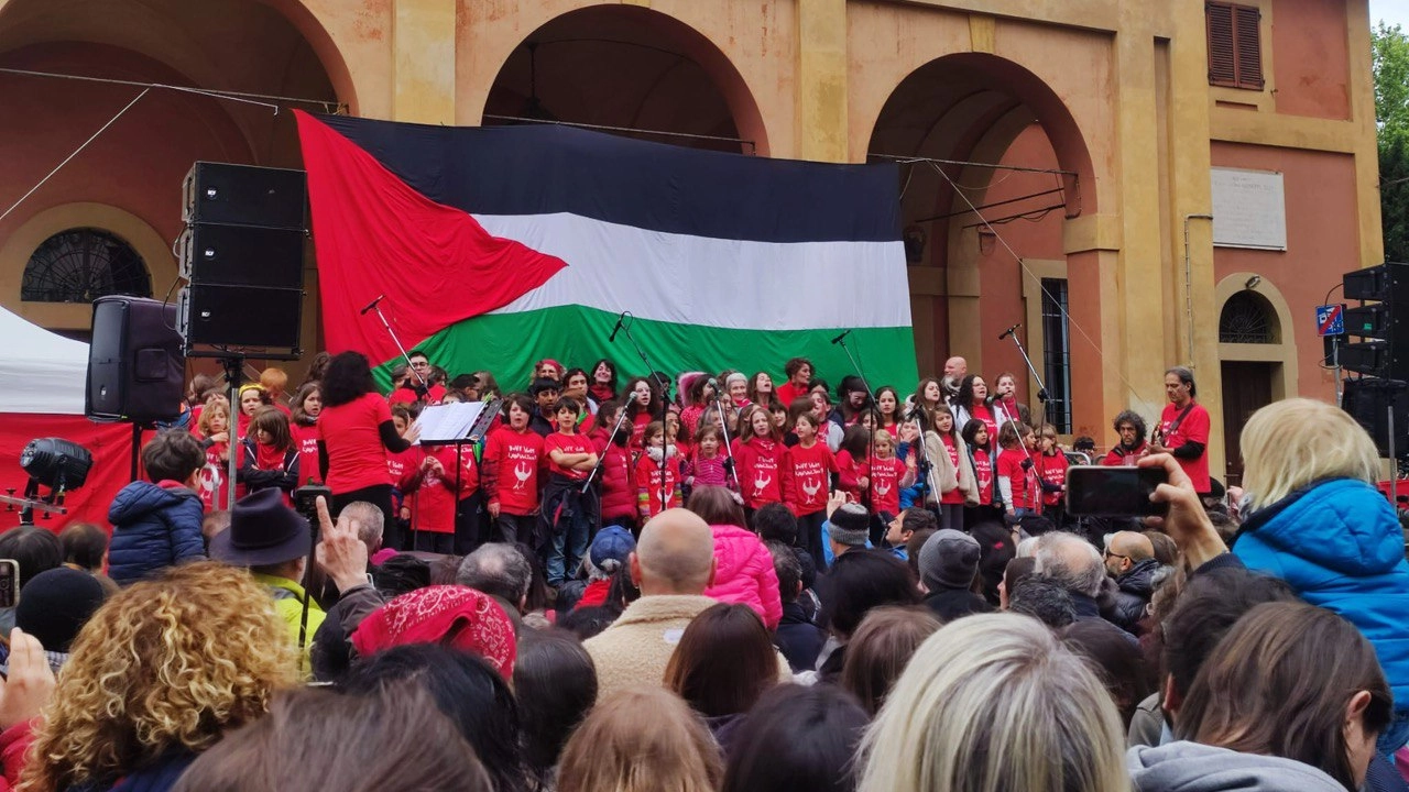 Al Pratello il coro dei bambini che cantano canzoni partigiane sotto la bandiera di Gaza