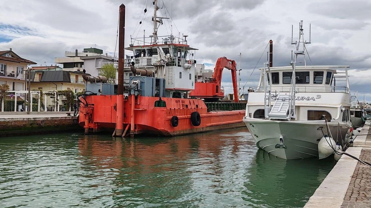 Il pontone de La Dragaggi che rimuove i (pochi) fanghi e la maxi-barca del Cantiere Morri destinata al trasporto turisti in Sardegna