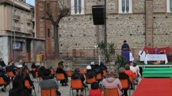 Una messa celebrata all’aperto con le sedie distanziate secondo le norme anti-contagio