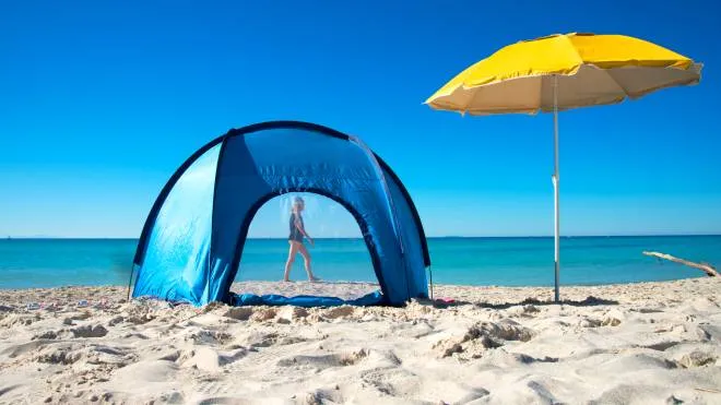 Camping tent and beach umbrella by the sea