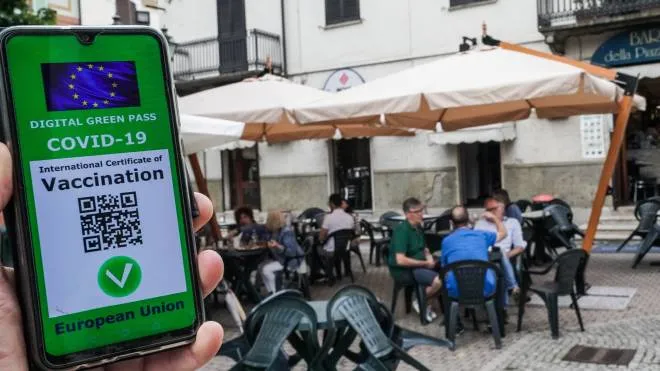 Una ricostruzione grafica del Green pass, il certificato digitale Covid dell'UE davanti ai tavoli di un locale ristorante, Torino 15 luglio 2021 ANSA/TINO ROMANO