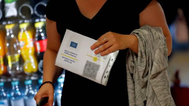 epa09412374 A Romanian tourist holds her printed Covid Digital Certificate before checking-in for her flight, at the departures terminal of Henri-Coanda International Airport, in Otopeni, Romania, 13 August 2021. Starting Friday, August 13, the COVID Digital Certificate, a proof of vaccination against Covid-19, passing through the disease or the negative result of an RT-PCR coronavirus test,  is the only document that allows entry into EU countries. The obligation to present the digital certificate refers only to the countries that require such documents at the border as well as the return to Romania from yellow and red list countries, according to the National Association of Agencies of Tourism. Crossing borders is possible without the existence of these certificates, but in compliance with the national quarantine rules of each state. The COVID digital certificate can be presented at customs both in print and on the phone, the validation being done using the QR code, which is scanned at the border.  EPA/ROBERT GHEMENT ATTENTION EDITORS: PERSONAL DATA BLURRED DUE TO DATA PRIVACY LAW