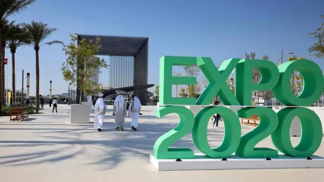 (FILES) In this file photo taken on January 16, 2021, people walk past the official Expo 2020 sign at the Dubai Expo in the United Arab Emirates. - The Covid-delayed Expo 2020 kicks off in Dubai on September 30 2021 with an extravagant opening ceremony in the evening for what is expected to be the world's biggest event since the start of the pandemic. (Photo by Karim SAHIB / AFP)