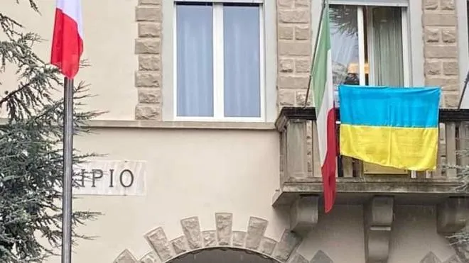 La bandiera ucraina al municipio di Sarsina e, nel riquadro, il sindaco Enrico Cangini