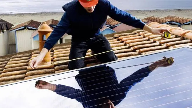 Un addetto al lavoro su un tetto per installare un impianto fotovoltaico (foto d’archivio)