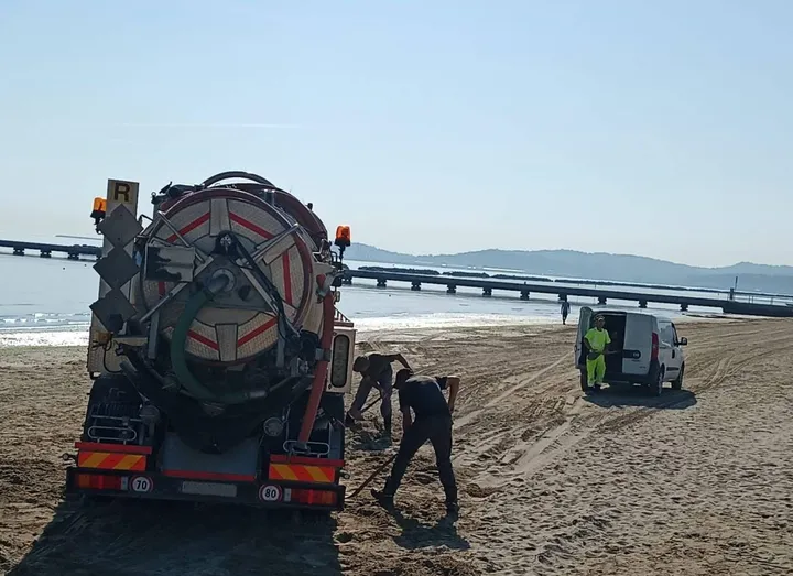 Si lavora per cercare di «liberare». un camion rimasto bloccato dalla sabbia: sembra che il problema nasca dai cumuli realizzati in inverno contro le mareggiate
