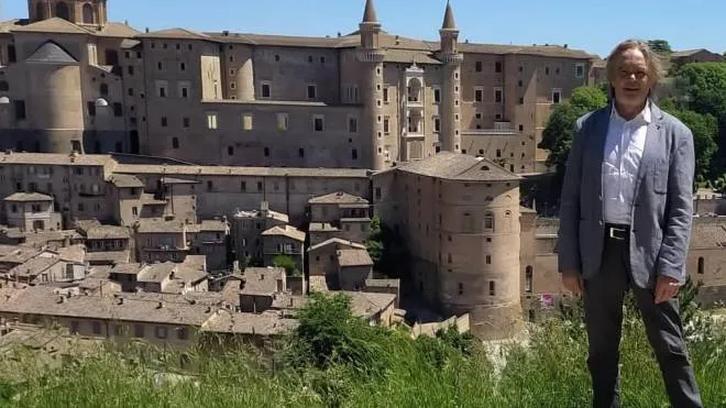 Valter Pandolfi tra l’erba alta alle vigne da dove si può ammirare un paesaggio di straordinaria bellezza, luogo indicato in nessun cartello turistico di Urbino