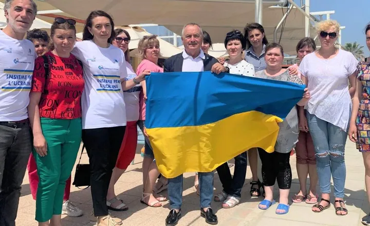 Giuliano Zignani (con la bandiera ucraina) con le profughe in fuga dalla guerra