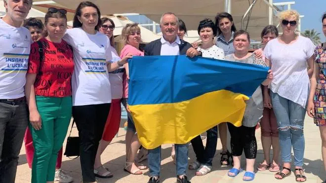 Giuliano Zignani (con la bandiera ucraina) con le profughe in fuga dalla guerra