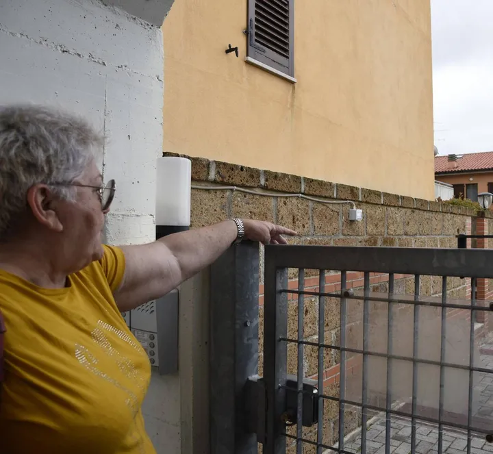 Una vicina di casa indica l’abitazione di via San Lorenzo a Montecosaro in cui è andata in scena la notte di follia (foto Calavita)