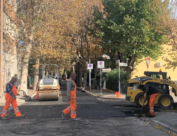 Una squadra di operai impegnati nell’asfaltatura di una strada
