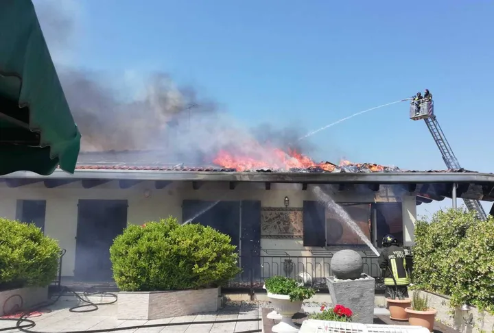 Vigili del fuoco in azione per spegnere il rogo che ha devastato un tetto coperto da pannelli solari, nell’abitazione privata accanto a un’azienda ittica