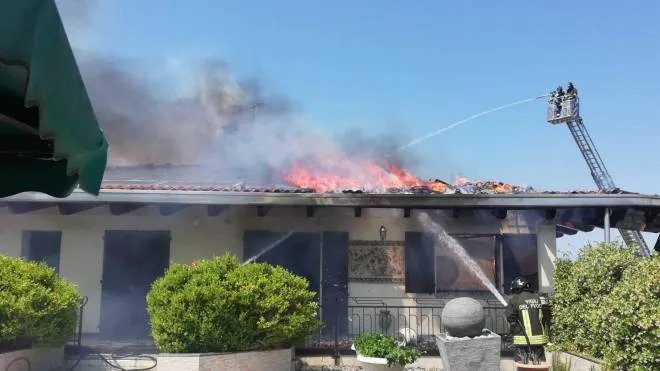 Vigili del fuoco in azione per spegnere il rogo che ha devastato un tetto coperto da pannelli solari, nell’abitazione privata accanto a un’azienda ittica