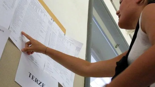 Una studentessa controlla il tabellone con i risultati degli alunni