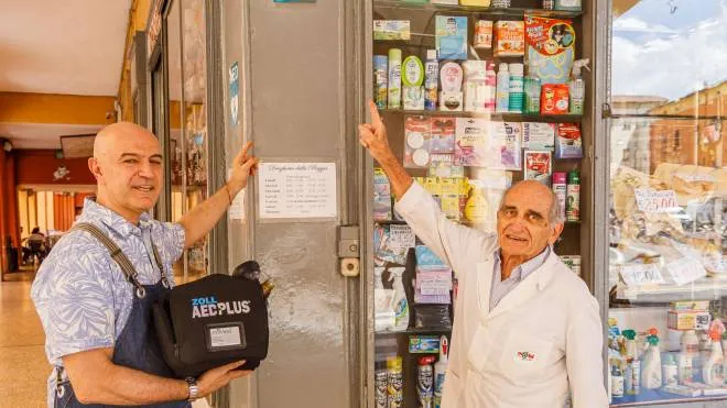 Il droghiere Luca Sarti con il defibrillatore e il macellaio Giancarlo Montanari: «La Madonna della Pioggia ci protegge»