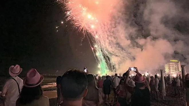 I fuochi d’artificio per la Notte Rosa visti dai turisti sulla spiaggia di Riccione
