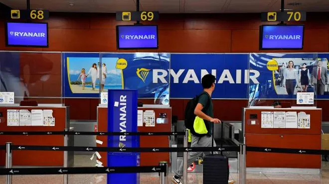 A man walks past Ryanair check-in counters at the Terminal 2 of El Prat airport in Barcelona on June 24, 2022. - Trade unions representing Ryanair cabin crew in Belgium, France, Italy, Portugal and Spain have called for strikes this coming weekend, while easyJet's operations in Spain face a nine-day strike next month. (Photo by Pau BARRENA / AFP)
