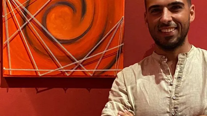 Il pittore Mattia Branchesi, 33 anni, accanto alla sua opera ’Legami’, che a ottobre sarà esposta al Louvre