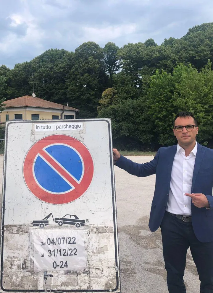 Il consigliere comunale e regionale della Lega. Luca Serfilippi mostra il cartello nel parcheggio di via Risorgimento