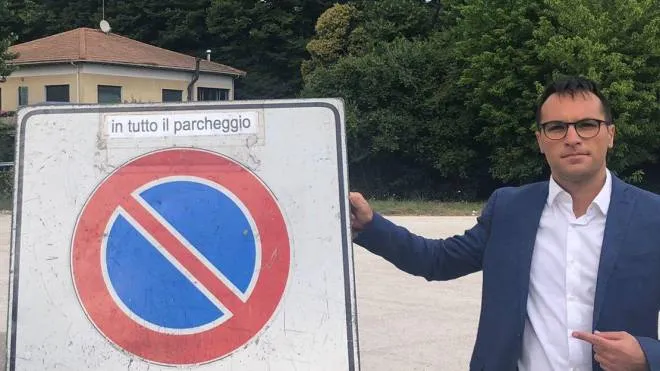 Il consigliere comunale e regionale della Lega. Luca Serfilippi mostra il cartello nel parcheggio di via Risorgimento