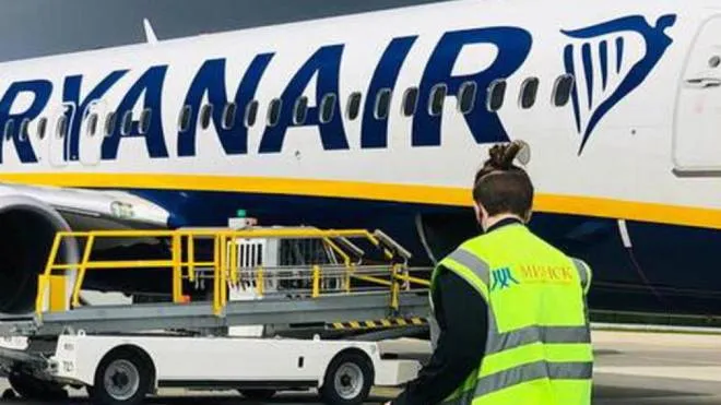 Un aereo Ryanair in pista e un addetto al carico dei bagagli (foto di repertorio)