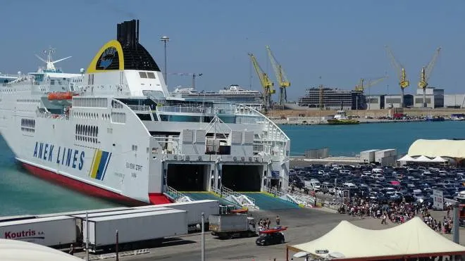 Un porto stracolmo di passeggeri e auto in attesa di essere imbarcate su uno dei traghetti per la Grecia