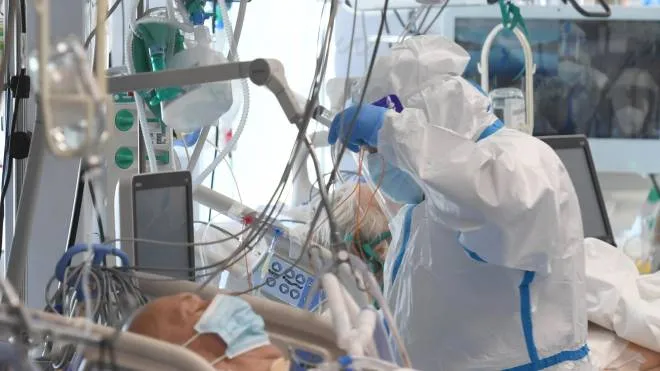 Un operatore sanitario intento a svolgere la sua mansione all’interno di un reperto di terapia intensiva