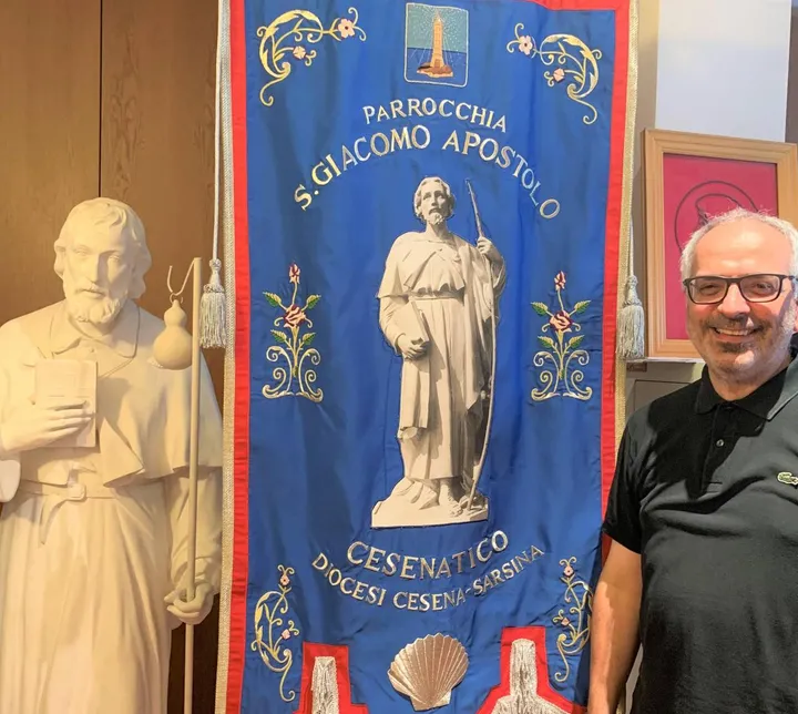 Don Gian Piero Casadei con la statua di San Giacomo e lo stendardo