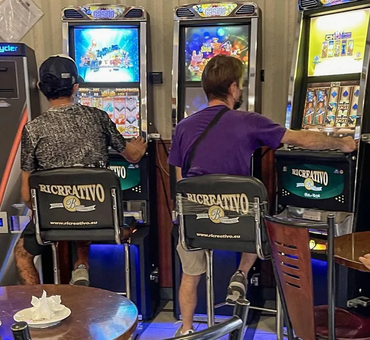 Due ragazzi giocano alle slot machines in un bar (immagine di repertorio)