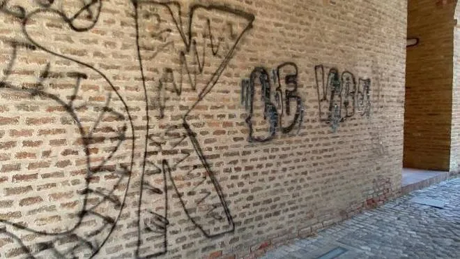 Le scritte che imbrattano uno dei muri di Palazzo Pio. I vandali sarebbero stati filmati