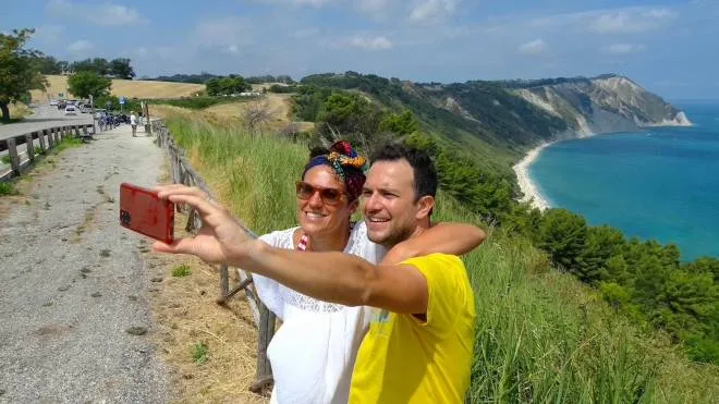 Al belvedere sopra la baia di Portonovo è diventata da tempo una consuetudine: selfie di rito con la grande bellezza