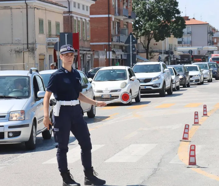 Un’agente di polizia locale che regola il traffico nell’arteria cittadina