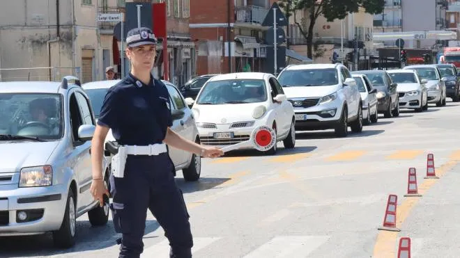 Un’agente di polizia locale che regola il traffico nell’arteria cittadina
