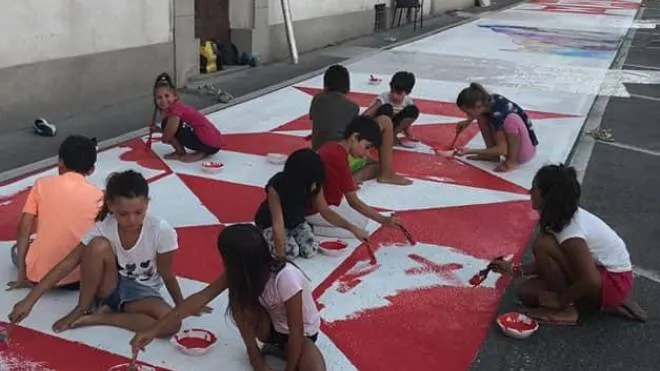 I piccoli del Borgo Fiorentino mentre dipingono i simboli della contrada sull’asfalto di piazza d’Armi