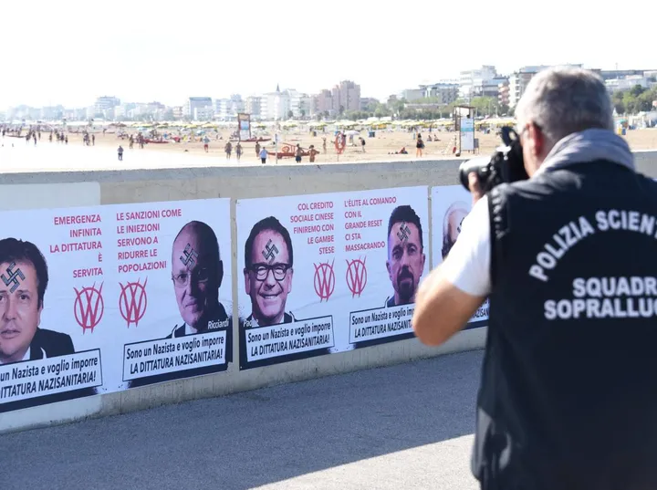 I rilievi della Polizia scientifica sui manifesti affissi dai vandali No vax (. foto Migliorini