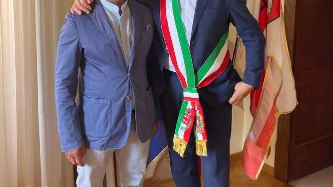 Il corriere Mhammed Diani con il sindaco Sandro Parcaroli per la consegna della cittadinanza italiana. In piccolo la pagina del Carlino dello scorso gennaio