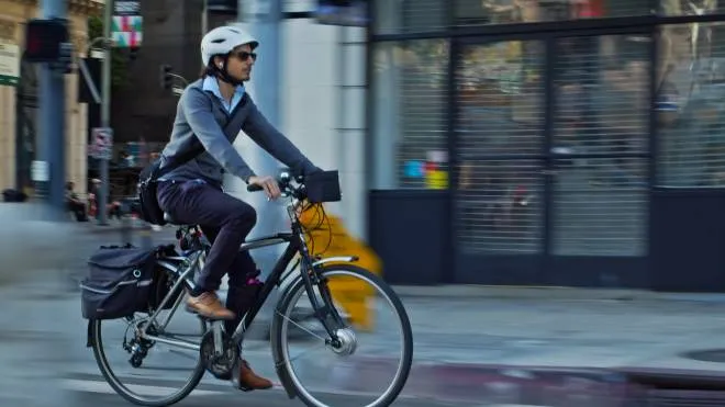 A middle aged man cycling to work on an e-bike in Downtown Los Angeles.
