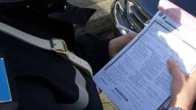 Un’agente della polizia locale mentre redige una multa per violazione al codice della strada. (Foto Ravaglia)