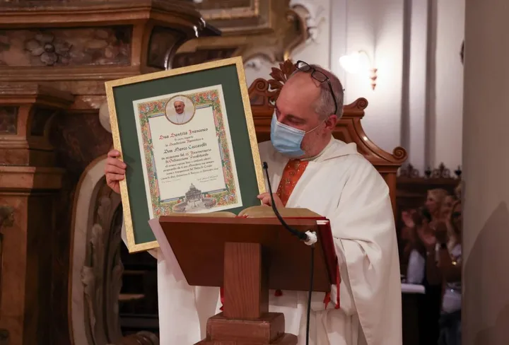 Don Marco Ceccarelli con la pergamena che è stata inviata dal papa per i festeggiamenti del 25esimo anniversario dell’ordinazione (Foto concessa da Frignani)