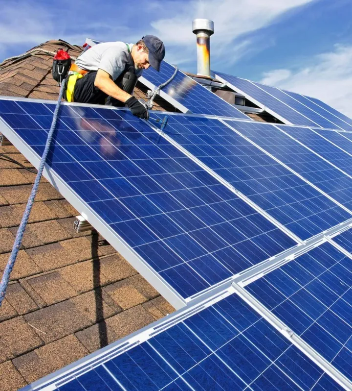 Un tecnico al lavoro per installare pannelli fotovoltaici sul tetto di un edificio