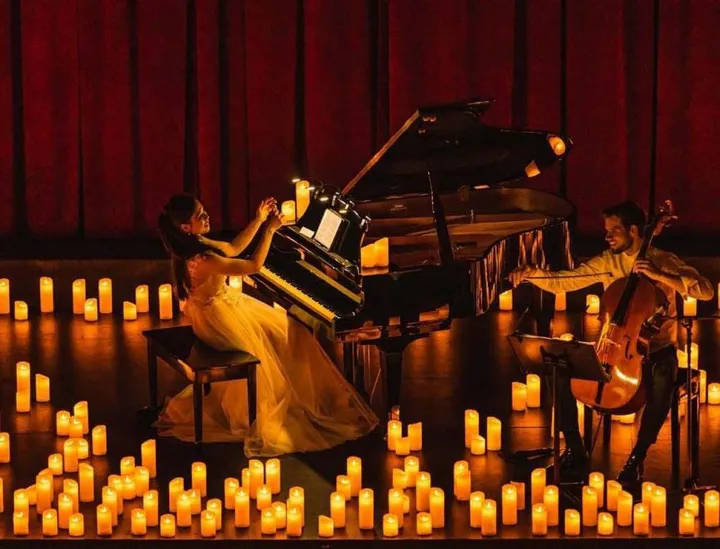 Un’artista al piano circondata dalla suggestiva luce delle candele
