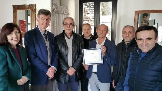 Umberto Maffei (al centro) riceve la targa alla presenza del sindaco e dei dirigenti della Cna