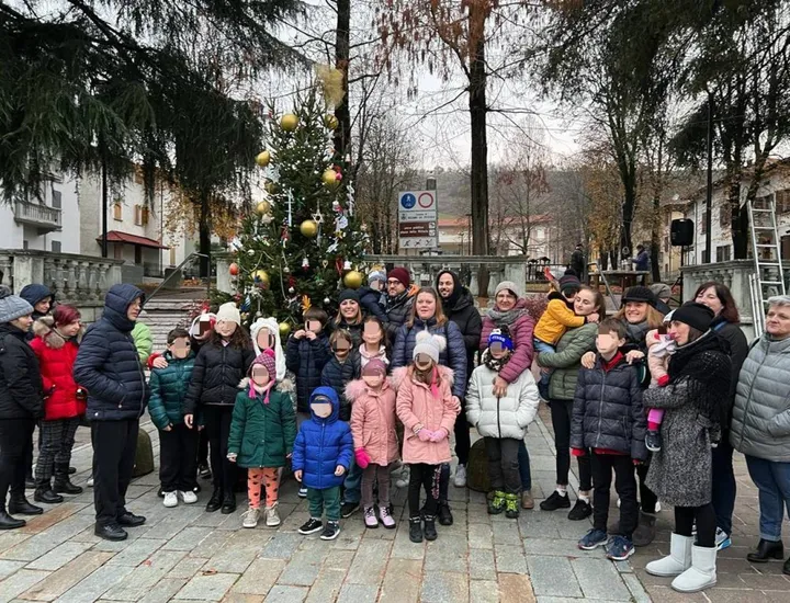 Bambini e famiglie. riuniti in piazza della Vittoria. per decorare l’albero di Natale
