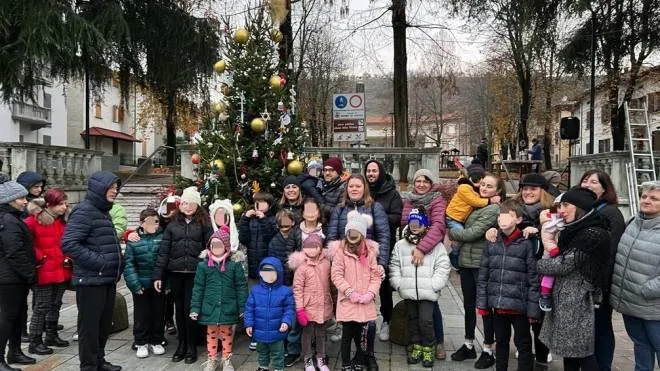 Bambini e famiglie. riuniti in piazza della Vittoria. per decorare l’albero di Natale